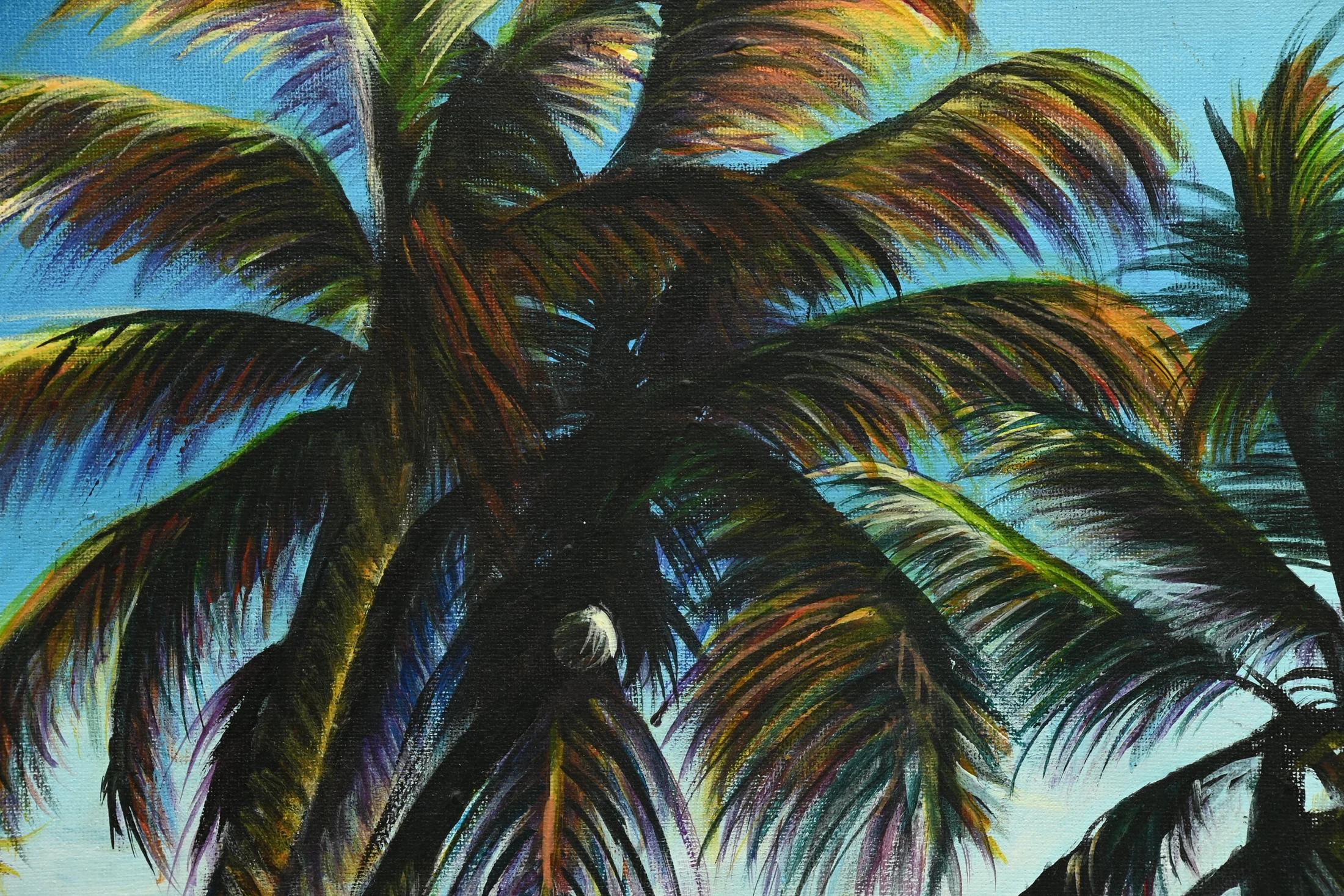 Close detail of layered palm fronds against the blue sky
